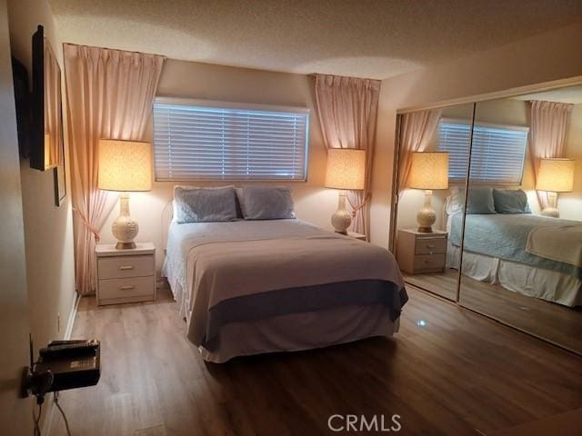 bedroom with a textured ceiling and light hardwood / wood-style flooring