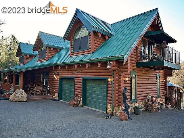 view of front of home with a porch, a balcony, and a garage