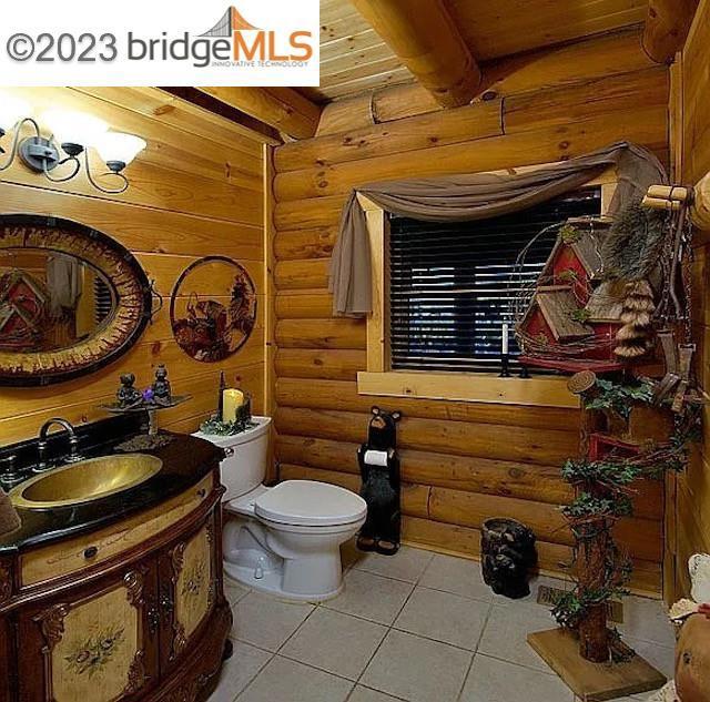 bathroom with toilet, vanity, tile patterned floors, and wood ceiling