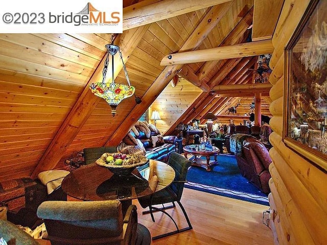 interior space with vaulted ceiling with beams, wood walls, wood ceiling, and light wood-type flooring