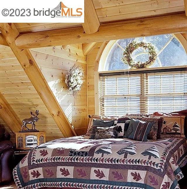 bedroom with vaulted ceiling with beams, wooden walls, and wooden ceiling