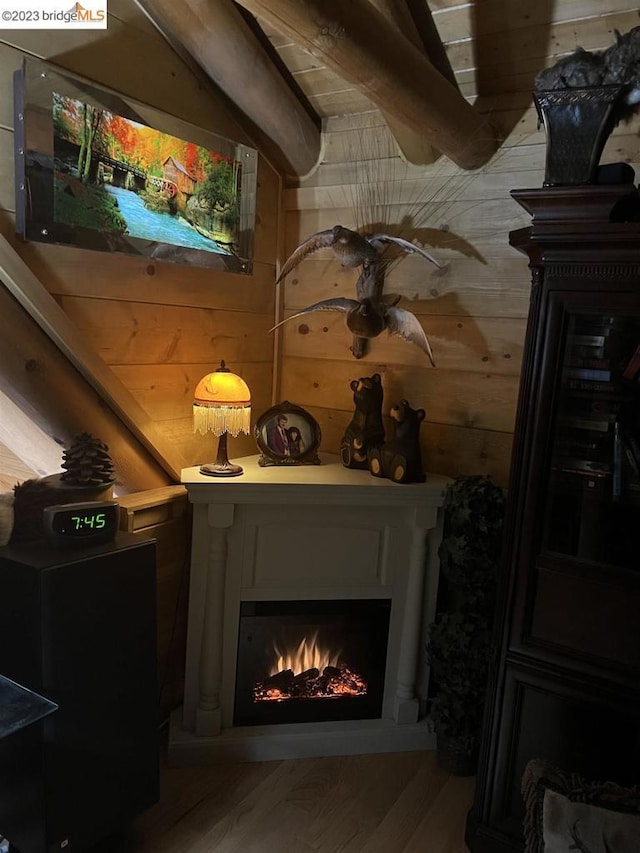 details with a fireplace, wood walls, and hardwood / wood-style floors