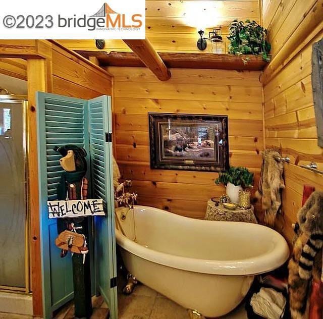 bathroom featuring wooden walls, beamed ceiling, and plus walk in shower