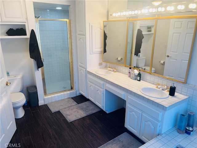 bathroom featuring decorative backsplash, an enclosed shower, vanity, and toilet