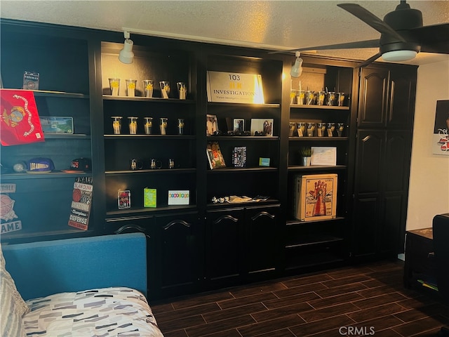 interior space featuring dark hardwood / wood-style flooring, ceiling fan, and a textured ceiling