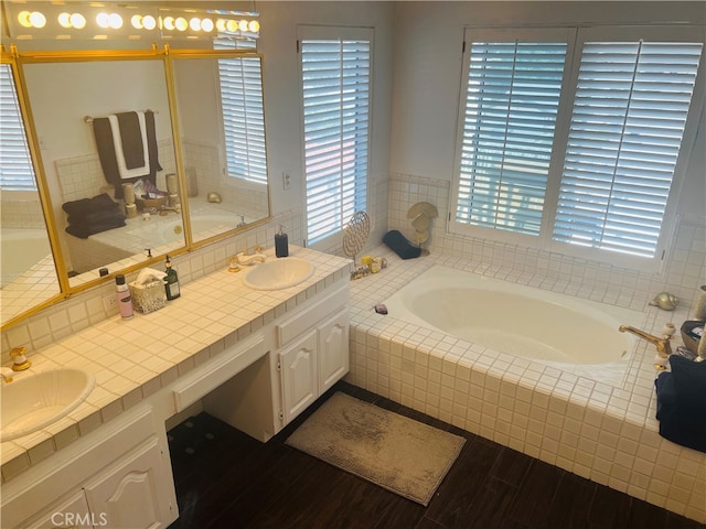 bathroom with a relaxing tiled tub and vanity