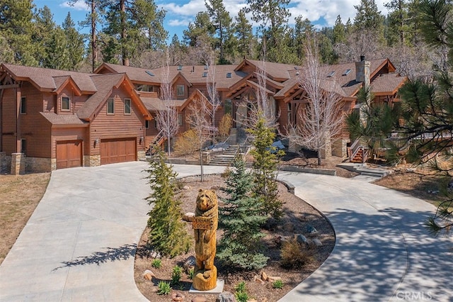 42143 Switzerland Dr, Big Bear, CA 92315 - view of front of home with stone siding, concrete driveway, and a garage