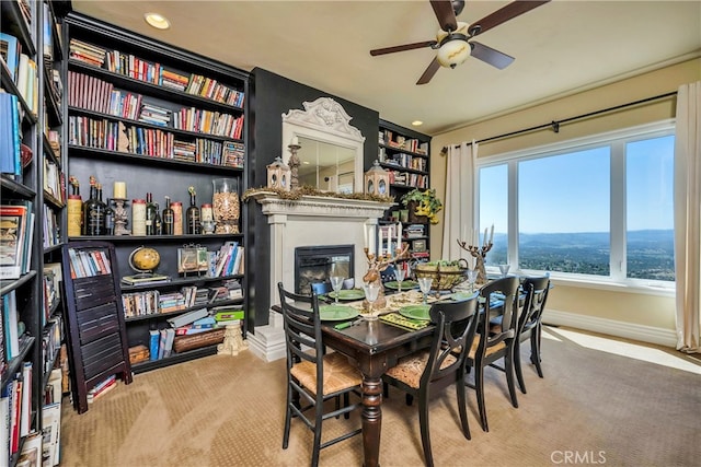 dining space featuring light carpet and ceiling fan