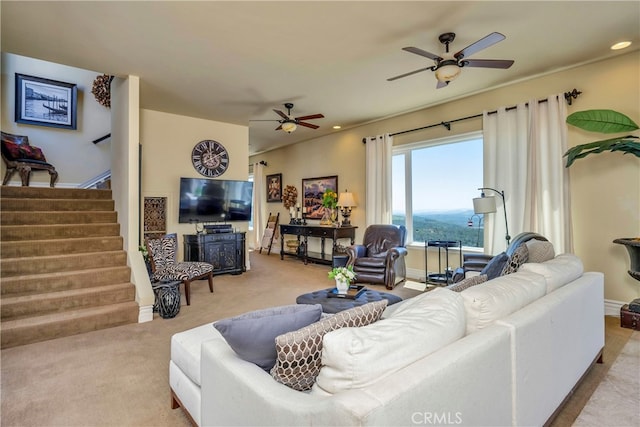 carpeted living room with ceiling fan