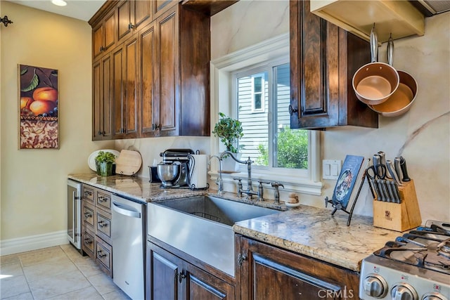 kitchen with wine cooler, light tile patterned floors, sink, appliances with stainless steel finishes, and light stone countertops