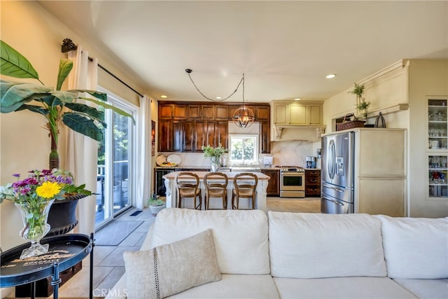 kitchen featuring decorative backsplash, appliances with stainless steel finishes, a breakfast bar, and a healthy amount of sunlight