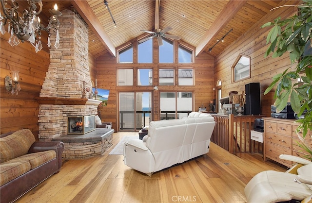 living room with plenty of natural light, high vaulted ceiling, light wood-type flooring, and beamed ceiling