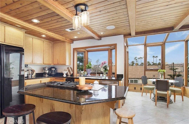 kitchen featuring wooden ceiling, a center island, beamed ceiling, and light brown cabinets