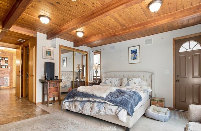 tiled bedroom with wood ceiling, beamed ceiling, and a closet