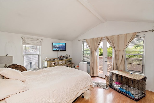 bedroom with wood-type flooring, vaulted ceiling with beams, and multiple windows