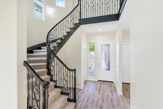 foyer entrance featuring light wood-type flooring and a high ceiling