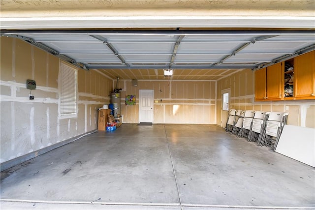 garage with strapped water heater, electric panel, and a garage door opener