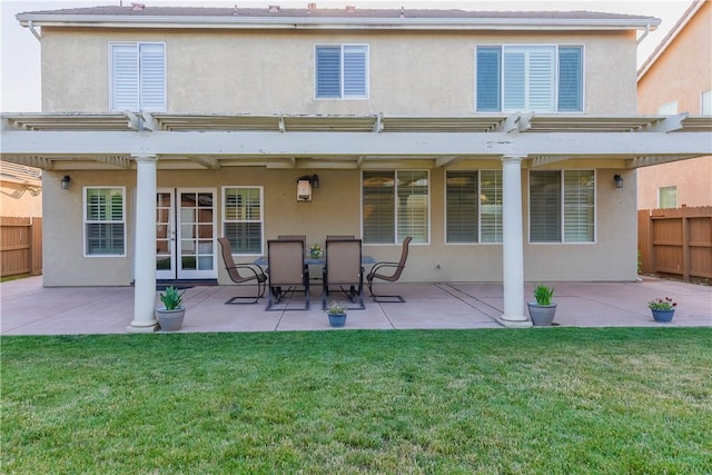 rear view of property featuring a lawn and a patio