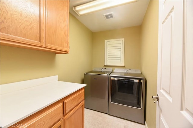 washroom featuring washer and clothes dryer and cabinets