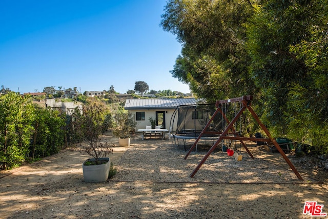 exterior space with a trampoline and a playground