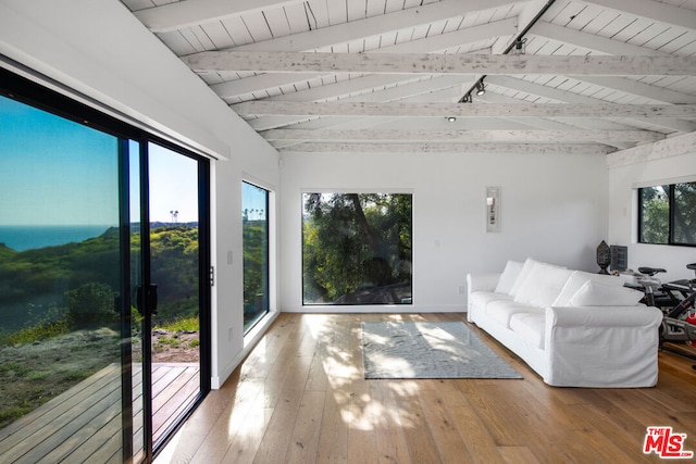 unfurnished sunroom featuring wooden ceiling, plenty of natural light, and lofted ceiling with beams