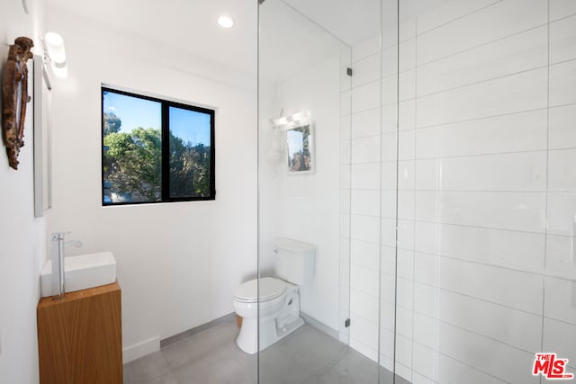 bathroom with a shower, tile patterned flooring, vanity, and toilet