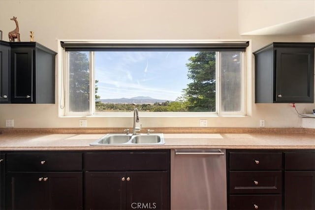 kitchen featuring dishwasher, a mountain view, light countertops, and a sink