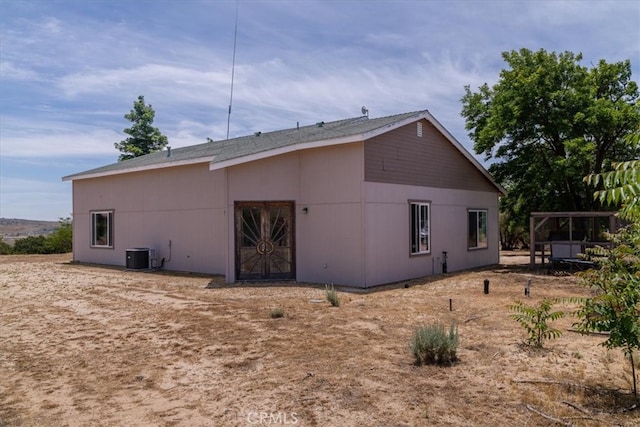 back of house with central AC unit