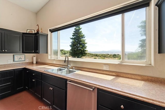 kitchen featuring a sink, light countertops, dark cabinetry, a wealth of natural light, and dishwasher