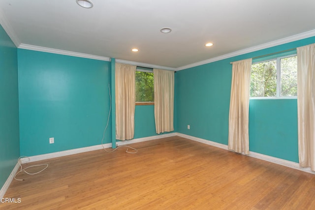 empty room with ornamental molding and wood-type flooring