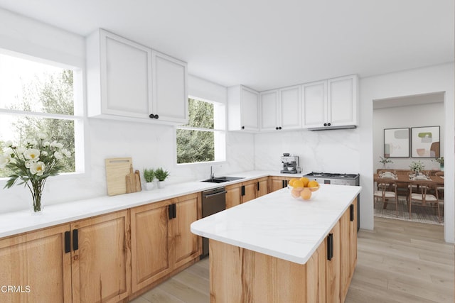 kitchen with light hardwood / wood-style floors, a kitchen island, sink, backsplash, and white cabinetry