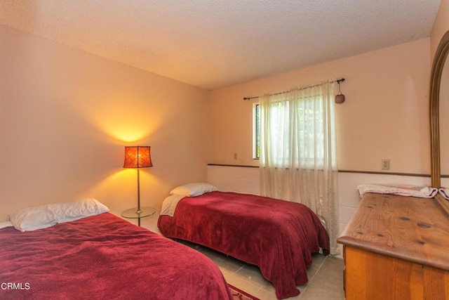 tiled bedroom featuring a textured ceiling