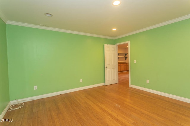 spare room featuring crown molding and hardwood / wood-style floors