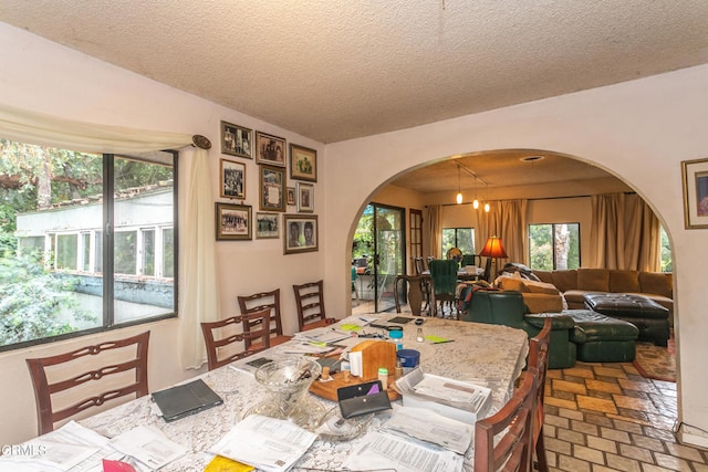 dining room with an inviting chandelier and a textured ceiling