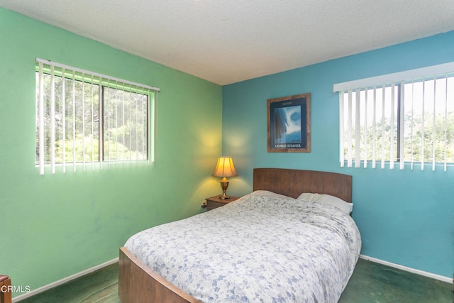 bedroom with dark colored carpet and a textured ceiling