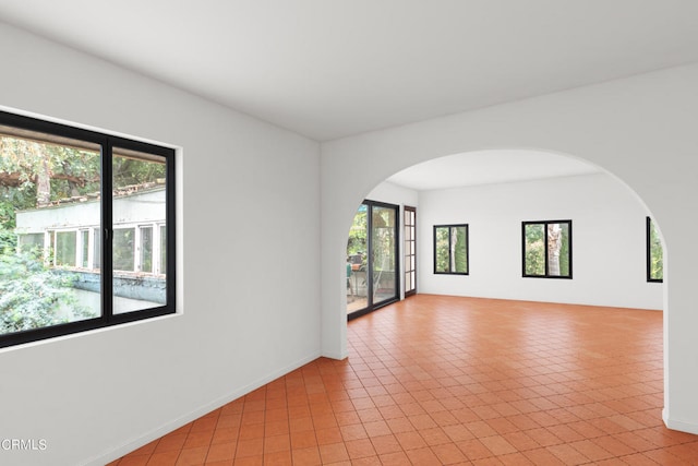 empty room with plenty of natural light and light tile patterned floors