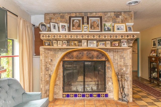 interior details featuring a textured ceiling and a large fireplace