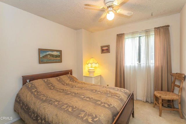 carpeted bedroom with ceiling fan and a textured ceiling