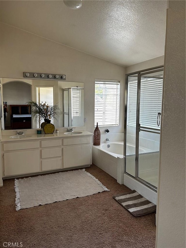 bathroom featuring plus walk in shower, a textured ceiling, vanity, and lofted ceiling