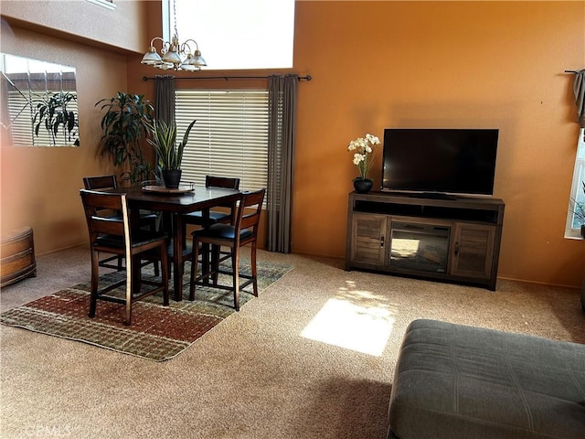 dining room featuring carpet, a notable chandelier, and a wealth of natural light