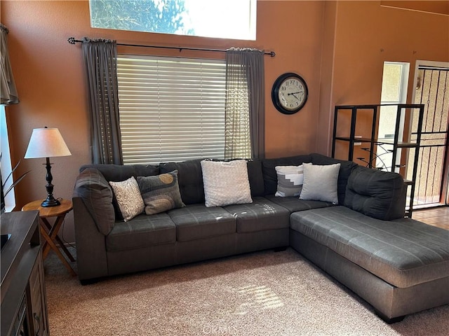 carpeted living room featuring a towering ceiling