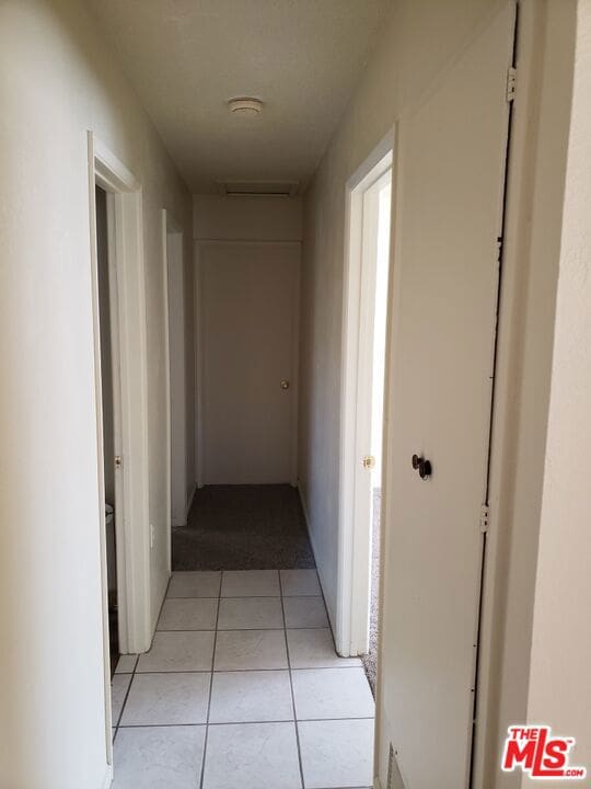 corridor featuring light tile patterned floors