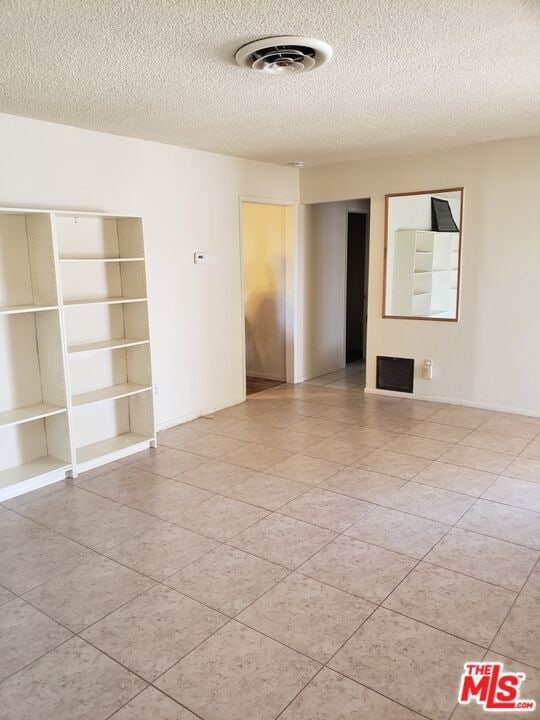 unfurnished room with a textured ceiling