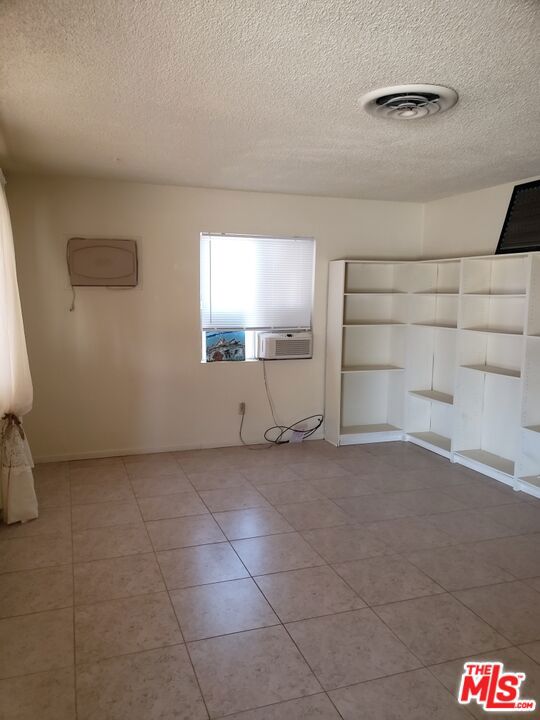 empty room with light tile patterned floors and a textured ceiling