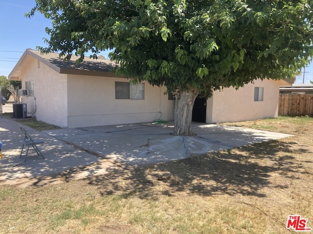 rear view of property with central AC unit and a patio area