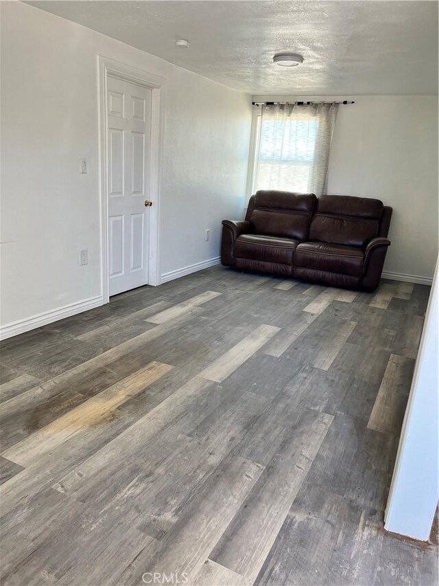 living room with dark wood-type flooring and a textured ceiling