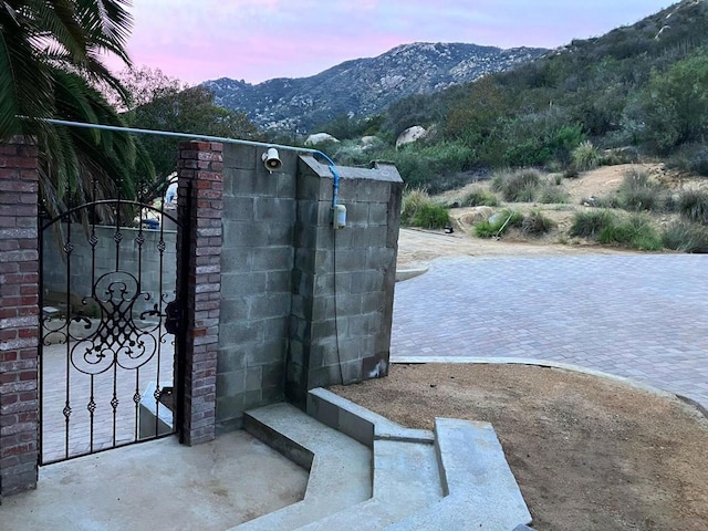 gate at dusk featuring a mountain view