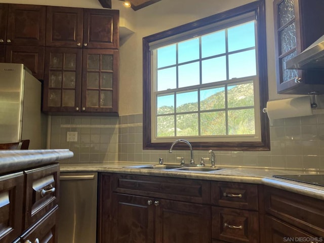 kitchen featuring backsplash, dark brown cabinets, sink, and white fridge