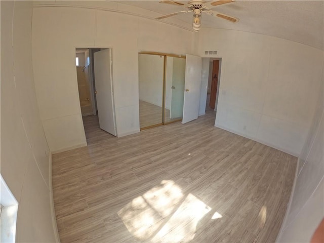 unfurnished bedroom featuring light hardwood / wood-style floors, ceiling fan, and lofted ceiling