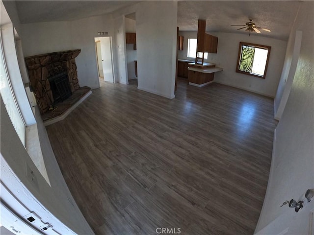 unfurnished living room with ceiling fan, dark hardwood / wood-style flooring, and lofted ceiling